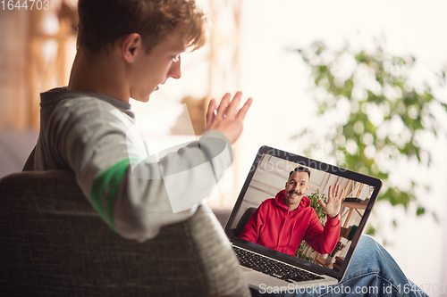 Image of Celebration and holidays during quarantine concept. Friends or family unpacking gifts while talking using video call