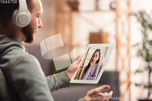 Image of Celebration and holidays during quarantine concept. Friends or family unpacking gifts while talking using video call