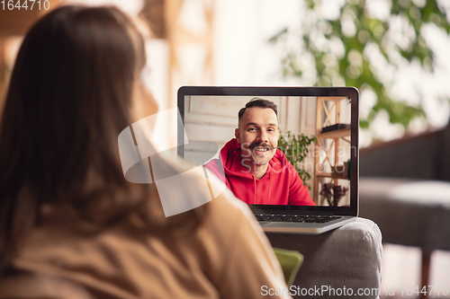 Image of Celebration and holidays during quarantine concept. Friends or family unpacking gifts while talking using video call