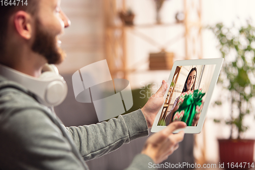 Image of Celebration and holidays during quarantine concept. Friends or family unpacking gifts while talking using video call
