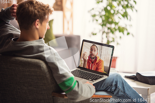 Image of Celebration and holidays during quarantine concept. Friends or family unpacking gifts while talking using video call