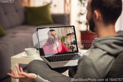 Image of Celebration and holidays during quarantine concept. Friends or family unpacking gifts while talking using video call