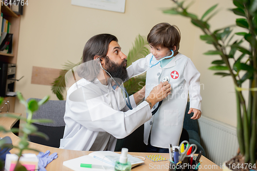 Image of Paediatrician doctor examining a child in comfortabe medical office