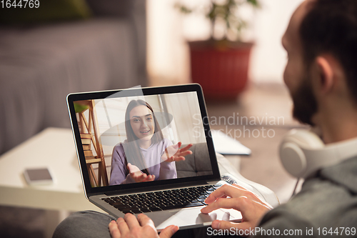 Image of Celebration and holidays during quarantine concept. Friends or family unpacking gifts while talking using video call