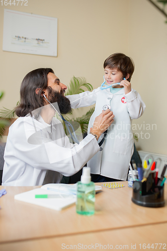 Image of Paediatrician doctor examining a child in comfortabe medical office