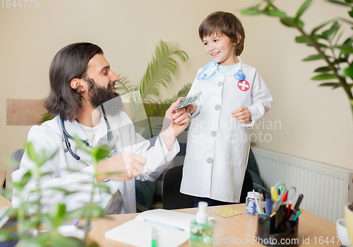 Image of Paediatrician doctor examining a child in comfortabe medical office