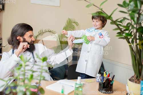 Image of Paediatrician doctor examining a child in comfortabe medical office