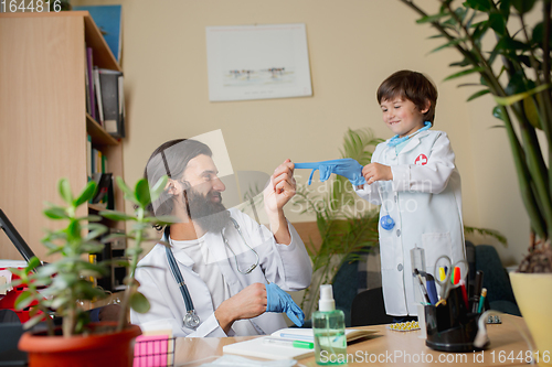 Image of Paediatrician doctor examining a child in comfortabe medical office