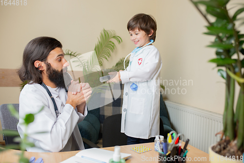 Image of Paediatrician doctor examining a child in comfortabe medical office