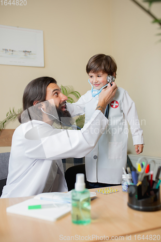 Image of Paediatrician doctor examining a child in comfortabe medical office