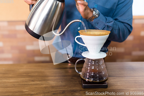 Image of Barista pouring water on coffe