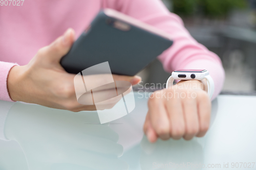 Image of Woman connecting cellphone and smart watch