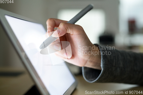 Image of Woman drawing on tablet with pen