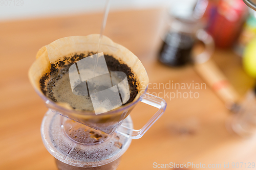 Image of Pouring hot water into coffee drip filter 