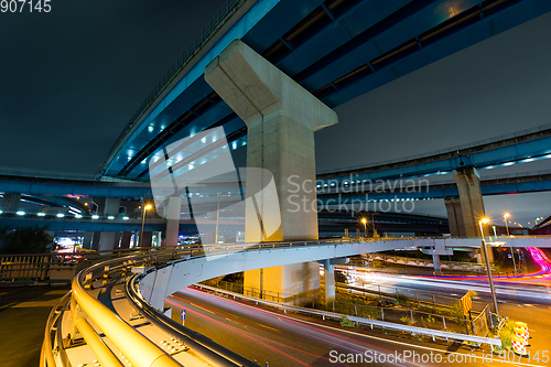 Image of Traffic and over head highway at night 