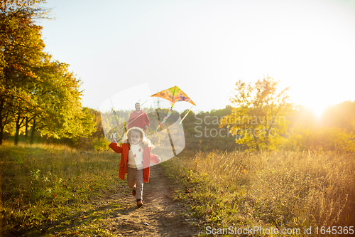 Image of Happy father and little cute daughter walking down the forest path in autumn sunny day