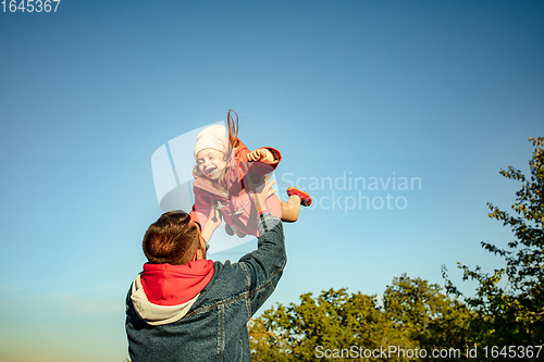 Image of Happy father and little cute daughter walking down the forest path in autumn sunny day