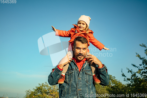 Image of Happy father and little cute daughter walking down the forest path in autumn sunny day