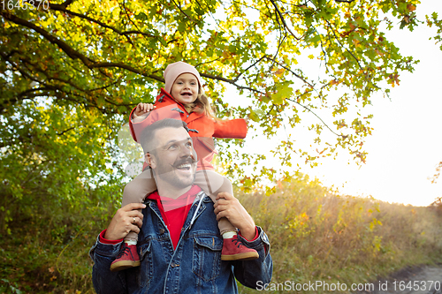 Image of Happy father and little cute daughter walking down the forest path in autumn sunny day