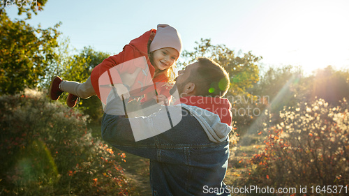 Image of Happy father and little cute daughter walking down the forest path in autumn sunny day