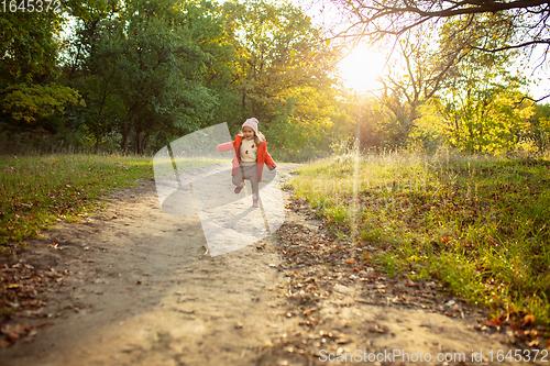 Image of Happy father and little cute daughter walking down the forest path in autumn sunny day