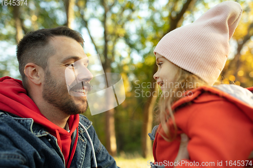 Image of Happy father and little cute daughter walking down the forest path in autumn sunny day