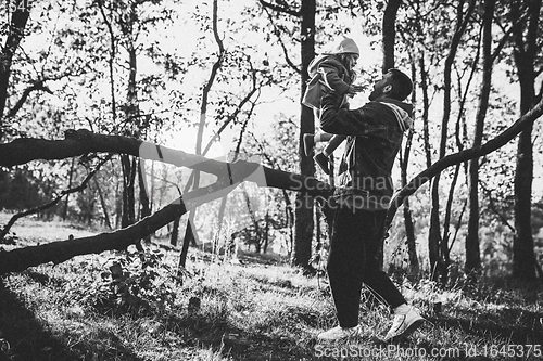 Image of Happy father and little cute daughter walking down the forest path in autumn sunny day