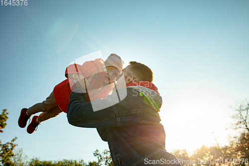 Image of Happy father and little cute daughter walking down the forest path in autumn sunny day