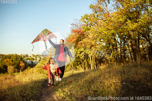 Image of Happy father and little cute daughter walking down the forest path in autumn sunny day