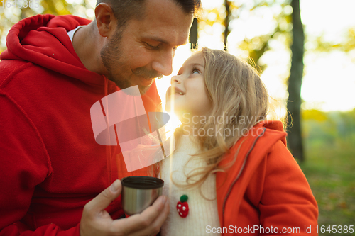 Image of Happy father and little cute daughter walking down the forest path in autumn sunny day