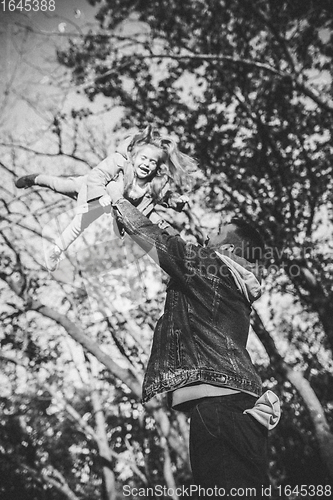 Image of Happy father and little cute daughter walking down the forest path in autumn sunny day