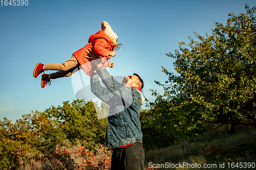 Image of Happy father and little cute daughter walking down the forest path in autumn sunny day