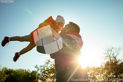 Image of Happy father and little cute daughter walking down the forest path in autumn sunny day