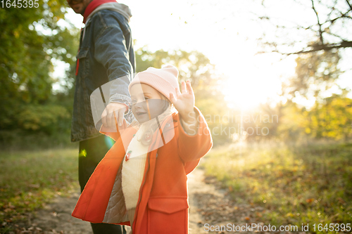 Image of Happy father and little cute daughter walking down the forest path in autumn sunny day