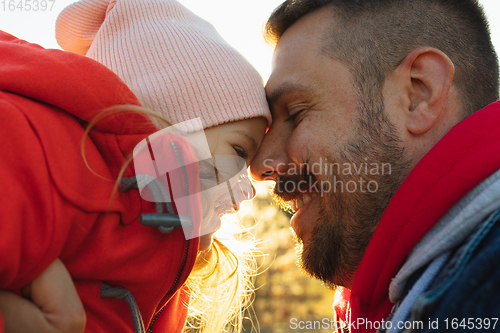 Image of Happy father and little cute daughter walking down the forest path in autumn sunny day