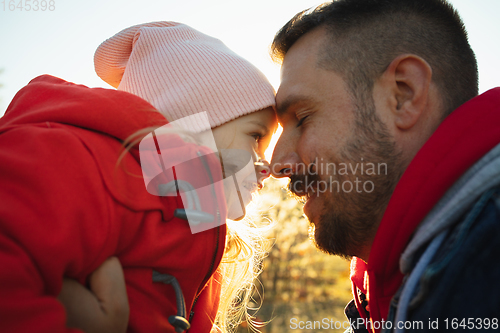 Image of Happy father and little cute daughter walking down the forest path in autumn sunny day