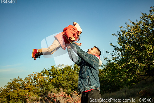 Image of Happy father and little cute daughter walking down the forest path in autumn sunny day