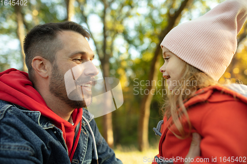 Image of Happy father and little cute daughter walking down the forest path in autumn sunny day