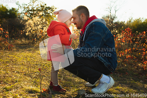 Image of Happy father and little cute daughter walking down the forest path in autumn sunny day