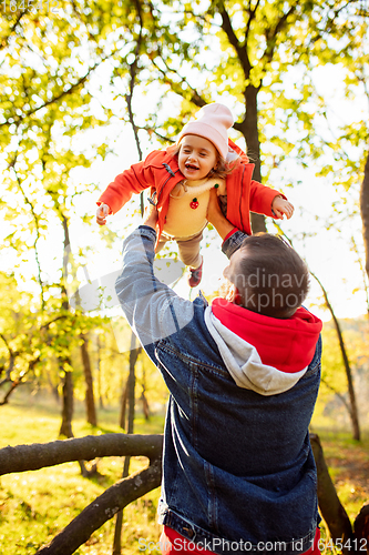 Image of Happy father and little cute daughter walking down the forest path in autumn sunny day