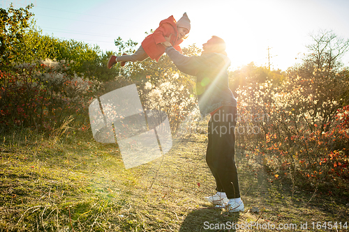 Image of Happy father and little cute daughter walking down the forest path in autumn sunny day