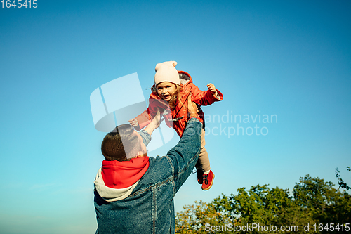 Image of Happy father and little cute daughter walking down the forest path in autumn sunny day