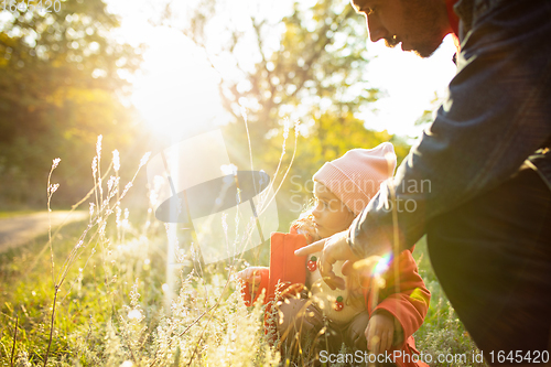 Image of Happy father and little cute daughter walking down the forest path in autumn sunny day