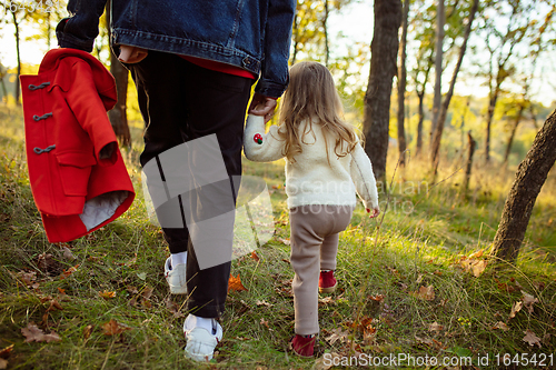 Image of Happy father and little cute daughter walking down the forest path in autumn sunny day