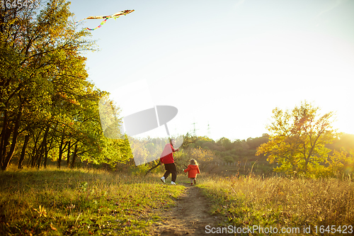 Image of Happy father and little cute daughter walking down the forest path in autumn sunny day