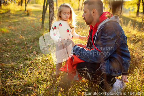 Image of Happy father and little cute daughter walking down the forest path in autumn sunny day