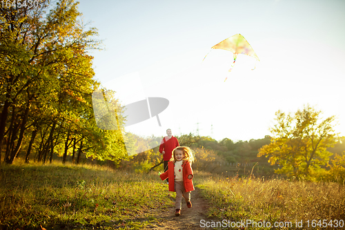 Image of Happy father and little cute daughter walking down the forest path in autumn sunny day