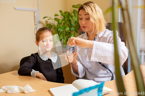 Image of Paediatrician doctor examining a child in comfortabe medical office