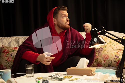 Image of Man wrapped in a plaid trying to protect from somebody\'s sick near by