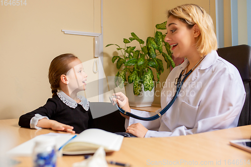 Image of Paediatrician doctor examining a child in comfortabe medical office